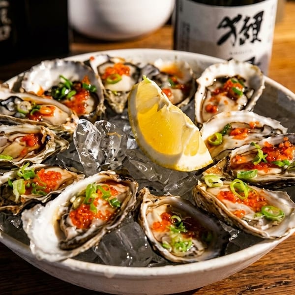 A dozen fresh oysters on ice with red roe, green onions, and a lemon wedge.